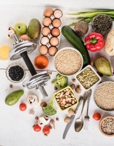Image showing a variety of nutritious foods arranged on a table. Includes fresh fruits like apples, berries, and oranges; vegetables like broccoli, carrots, and leafy greens; lean proteins such as grilled chicken and salmon; whole grains like quinoa and brown rice; and healthy fats such as avocados and almonds. The colorful display highlights a balanced diet rich in essential nutrients.