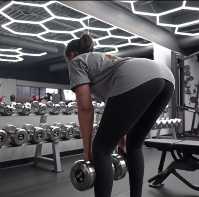 woman performing dumbbell RDL exercise