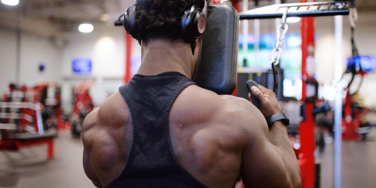 back of black man performing chest supported lat pulldown